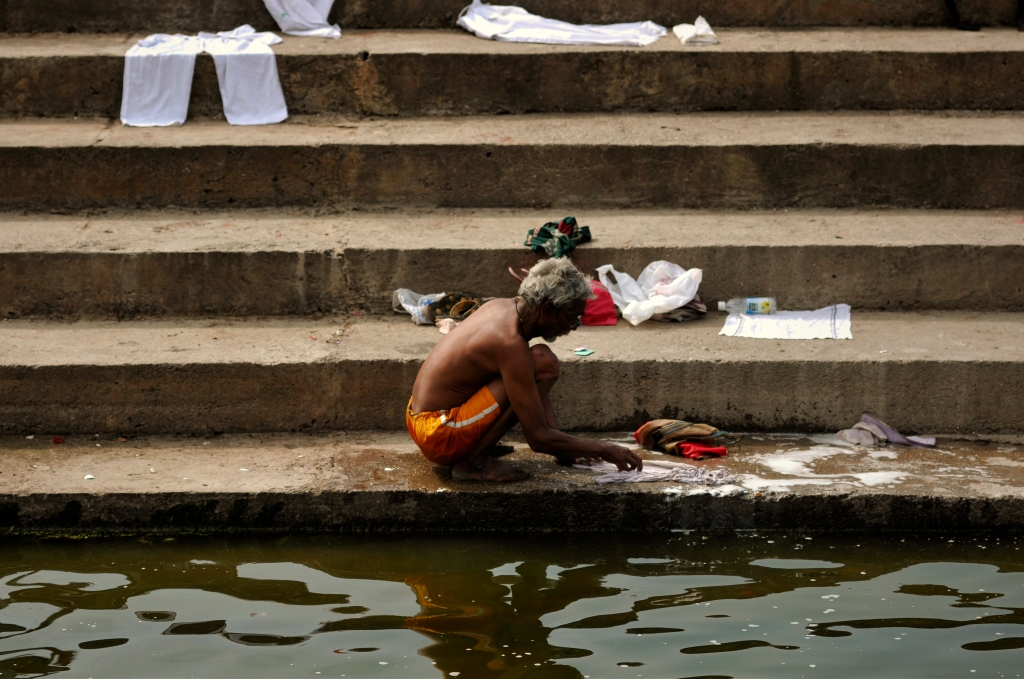 Photo of an Indian man washing clothes in India.