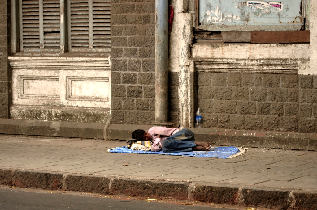 Photo of an Indian boy sleeping in the street in India.